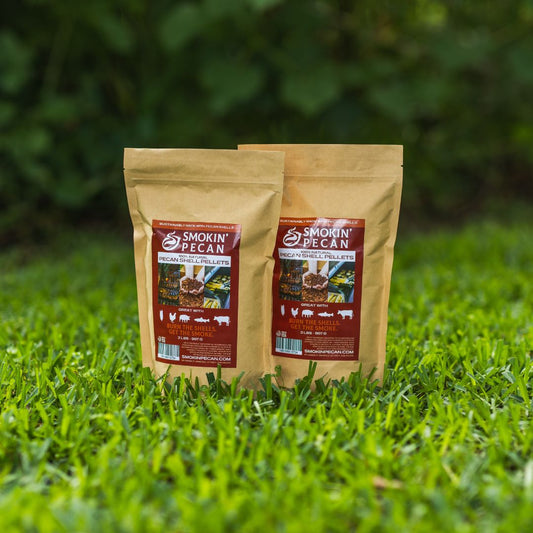 Two packages of 'Smokin' Pecan' pecan shell pellets on grass