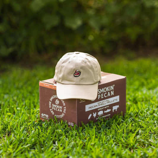 Beige cap on a box of Smokin' Pecan Pellets in grass